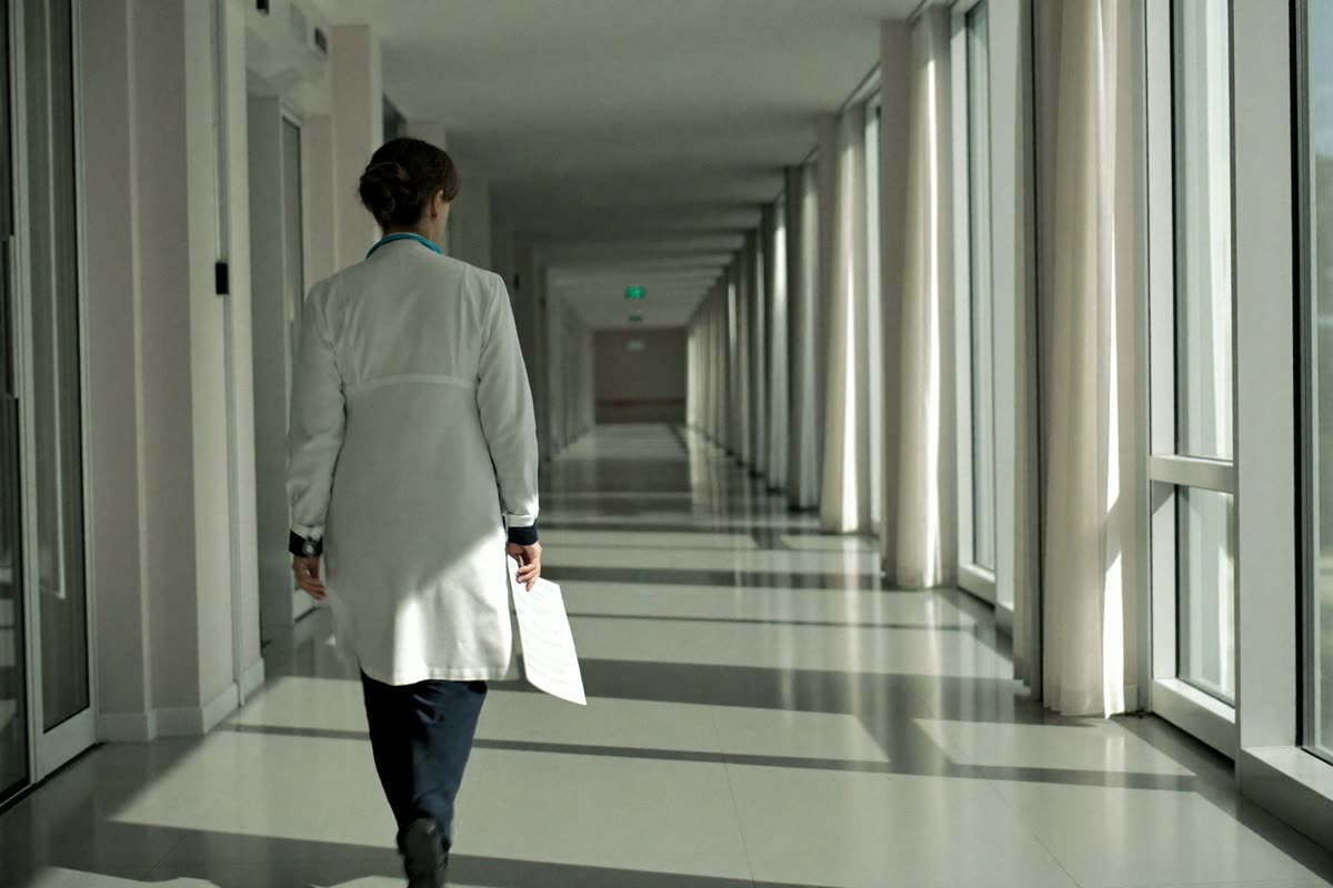 Ärztin geht durch einen hellen Klinikflur